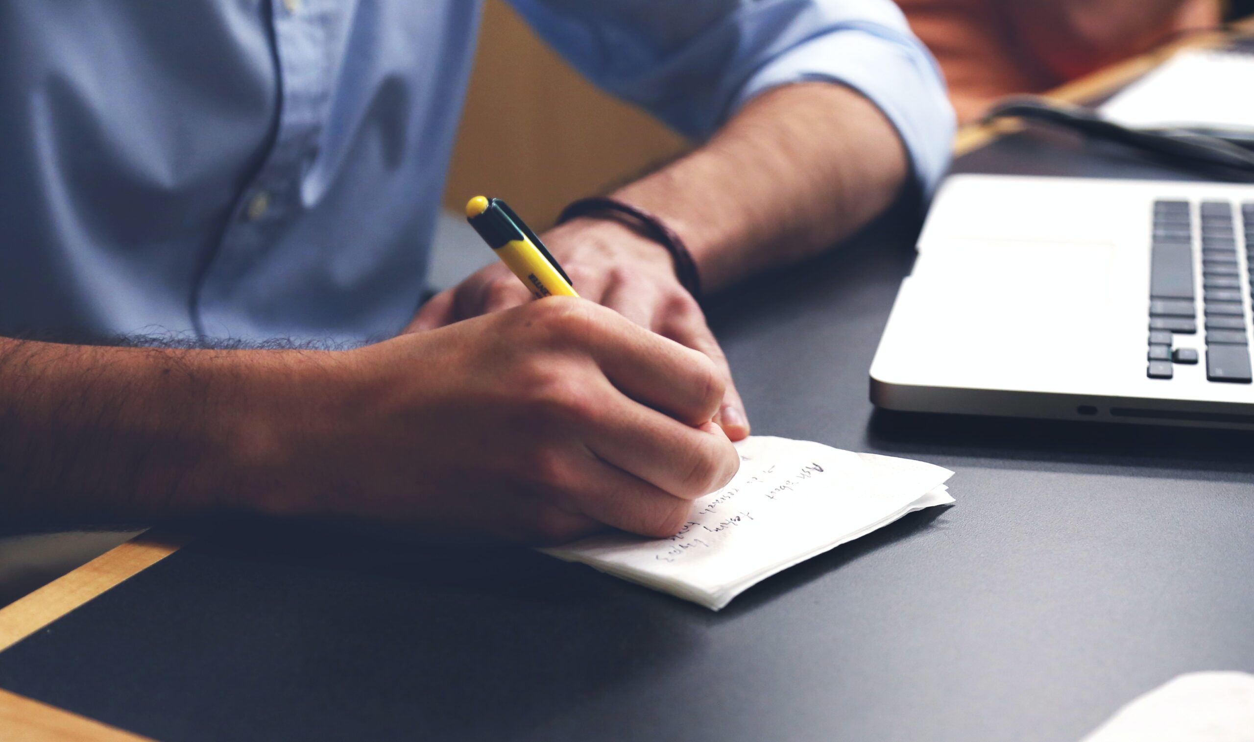 Free Person Writing on Paper Using Yellow and Black Pen Stock Photo